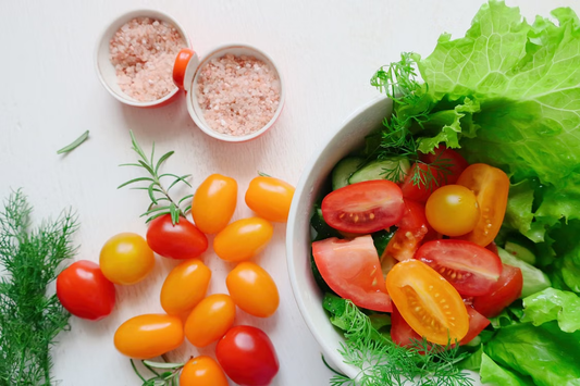 Sliced tomatoes and green vegetables in a white bowl