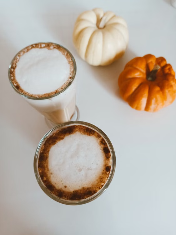 Pumpkins and coffee arranged on a table