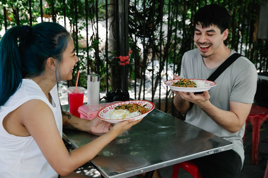 Two friends enjoying a meal together at an outdoor restaurant.