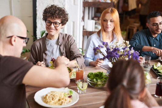 A group of friends enjoying a meal together around a dining table.