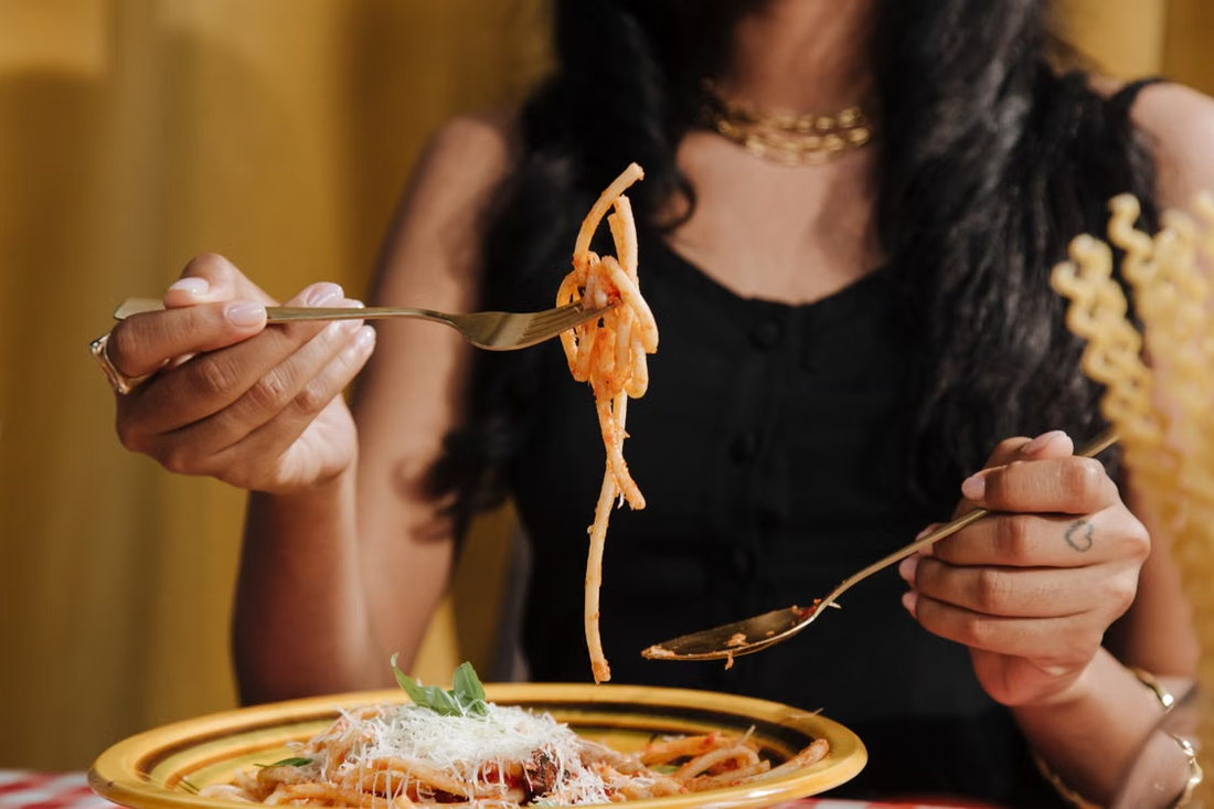 A person enjoying a flavorful pasta meal